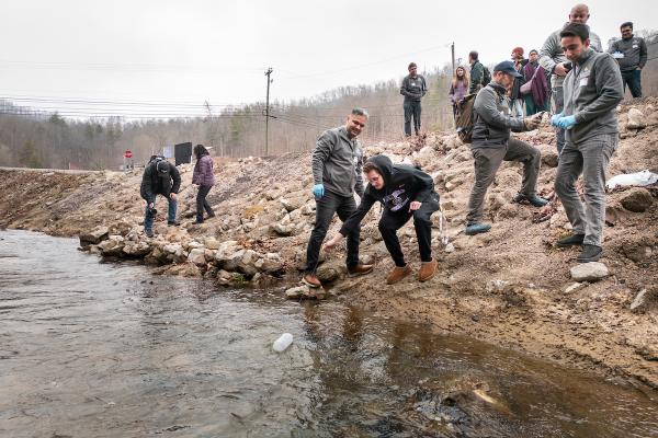 Student collect water sample at creek