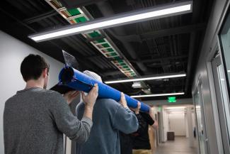 Student Carrying Rocket through hallway
